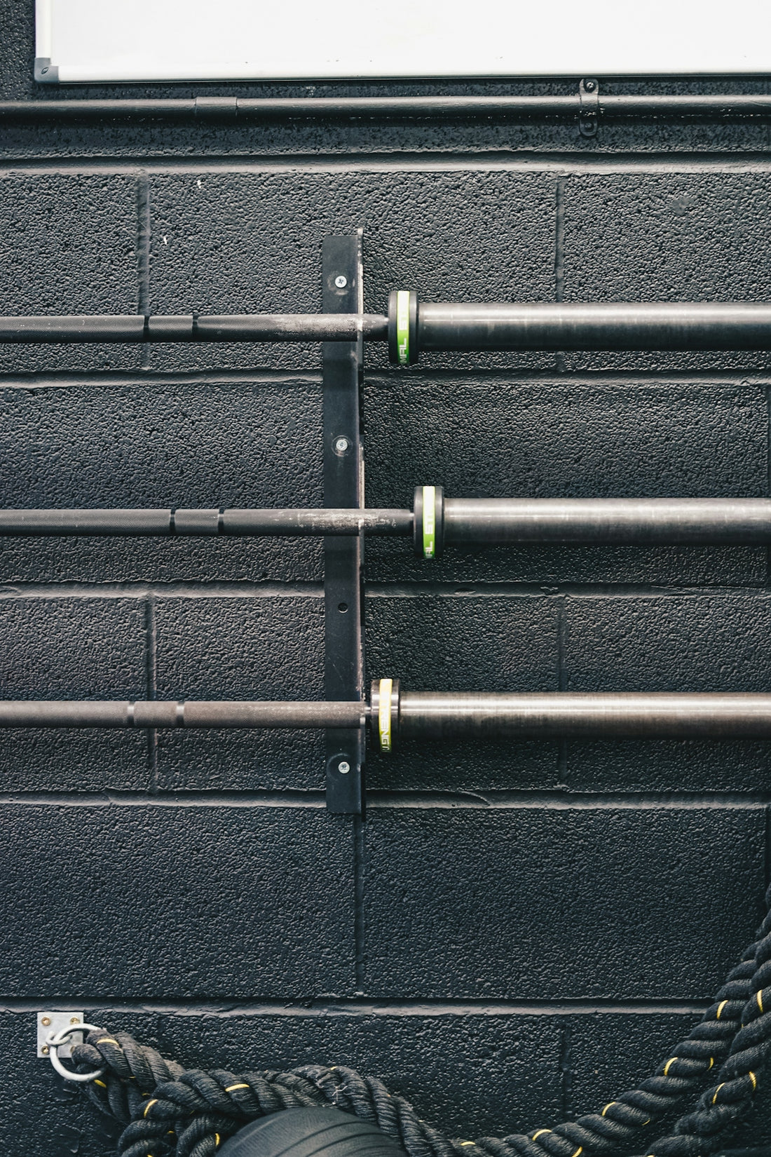 a black wall with metal pipes and a tire
