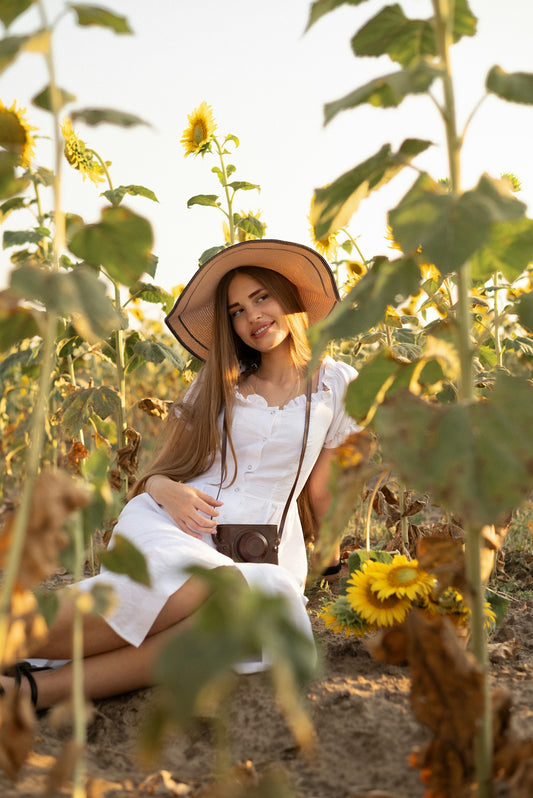 A woman sitting in a field of sunflowers
