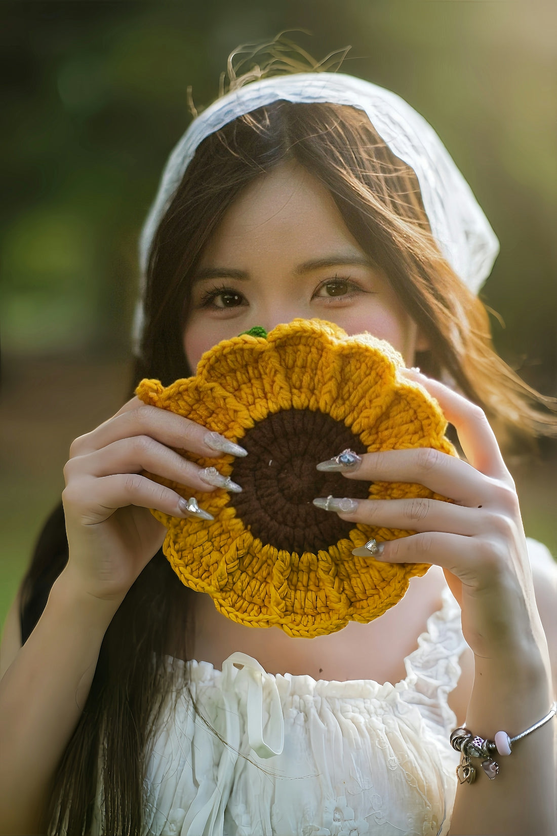 Young woman holding a crocheted sunflower to her face