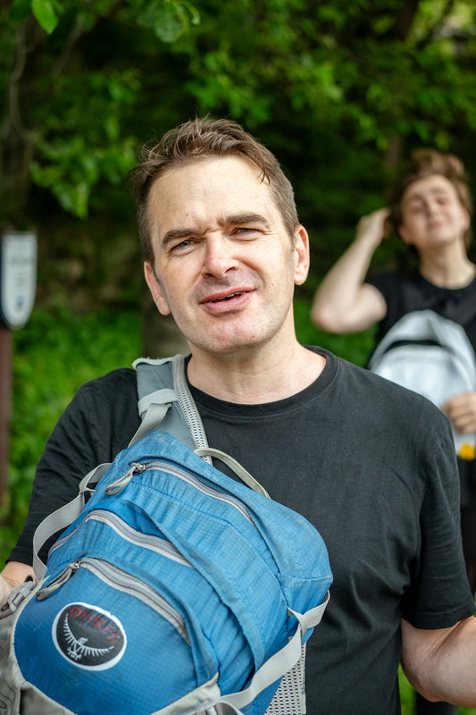 Man with backpack looking at camera outdoors