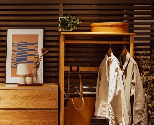 Wooden dresser with artwork and hanging coats